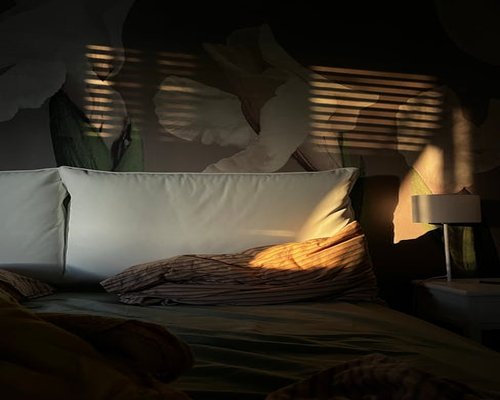 A calm bedroom scene with soft warm lighting and comfortable pillows